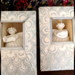 Two holiday angel ornaments made of bisque/porcelain. Both still in original box